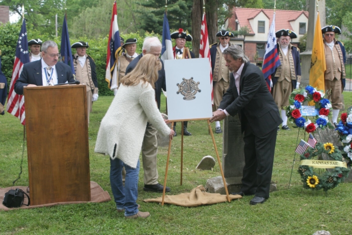 Members dedicating a Patriot grave marker beside a wreath